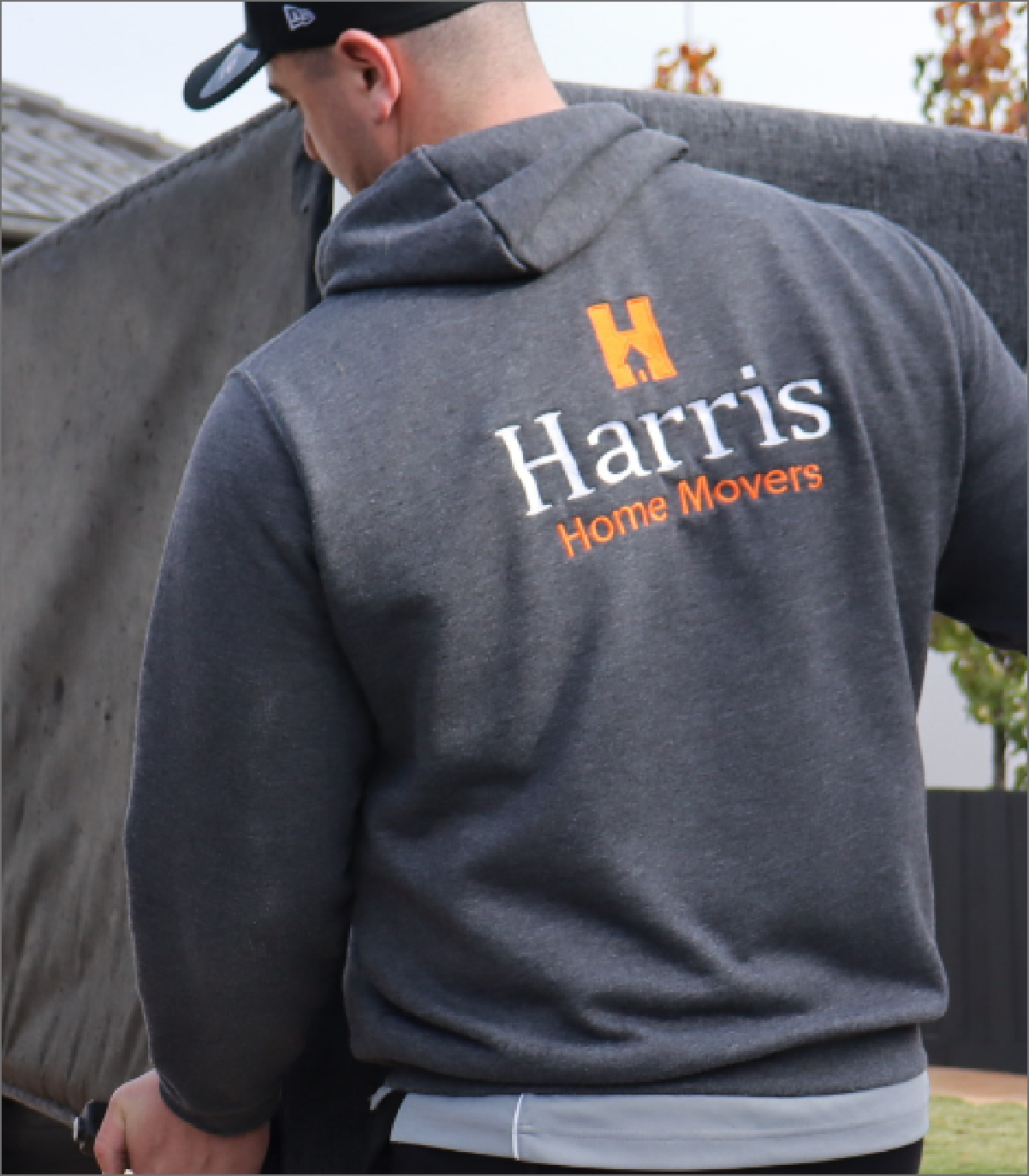 Harris Home Movers branded hoodie on a removalist lifting furniture
